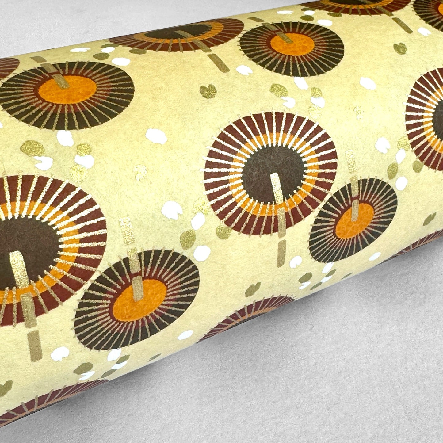 Japanese silkscreen chiyogami paper with a brown and orange umbrella pattern on a buttermilk backdrop