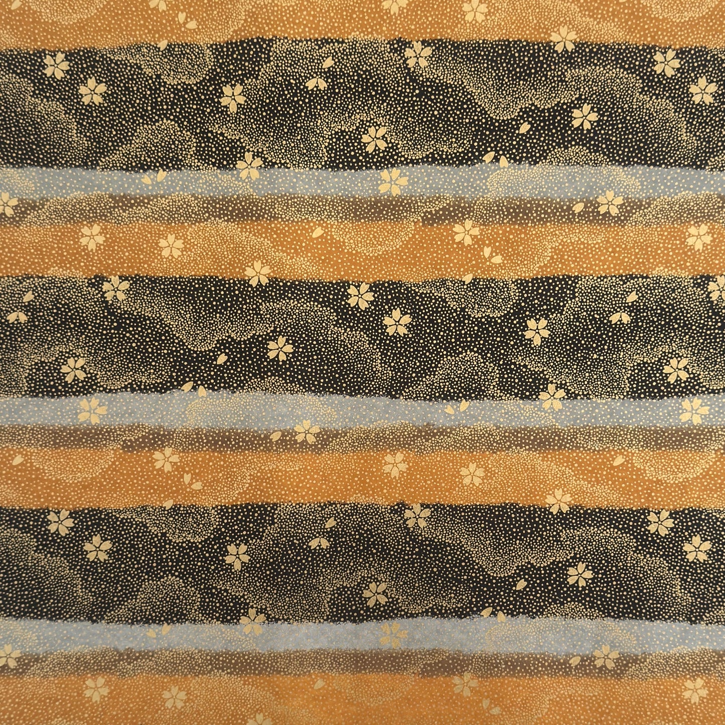 japanese chiyogami paper in stripes of black, brown, ochre and grey with gold clouds and flowers