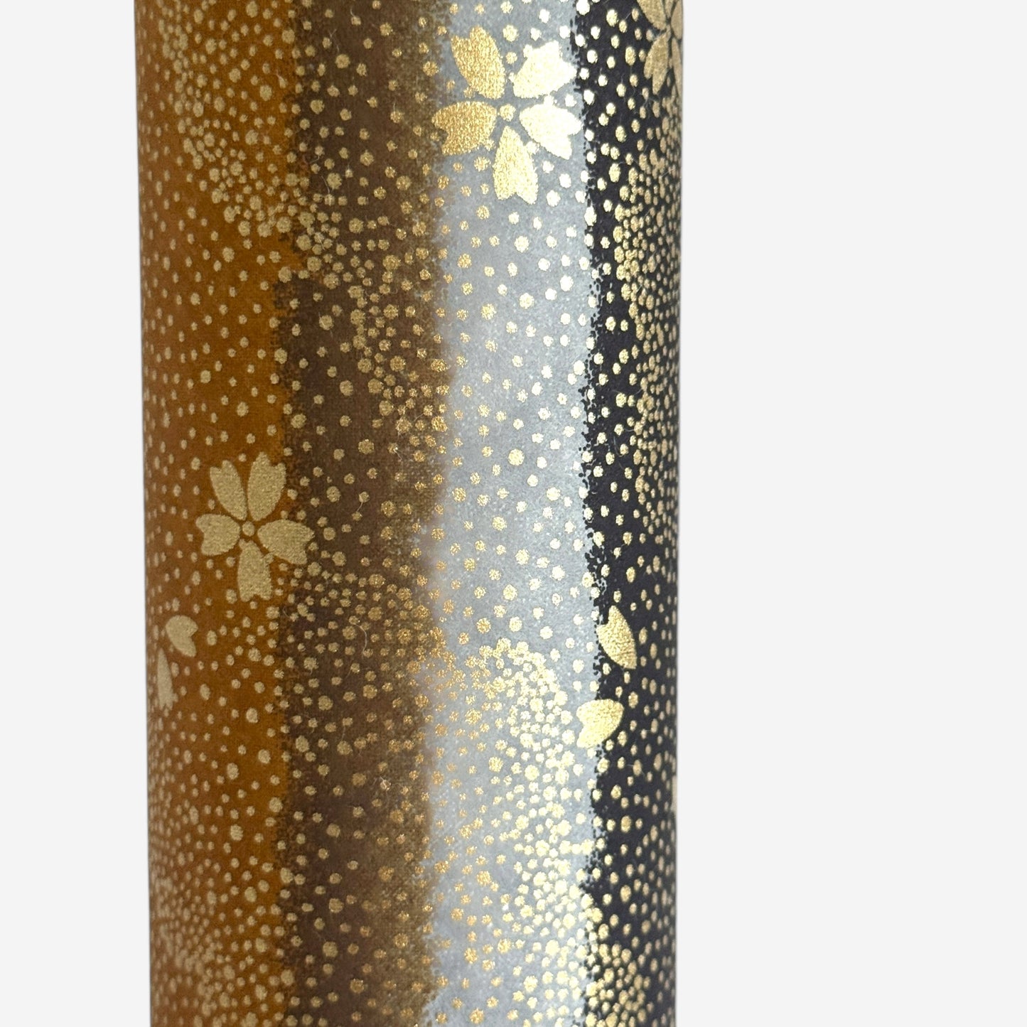 japanese chiyogami paper in stripes of black, brown, ochre and grey with gold clouds and flowers. Close up