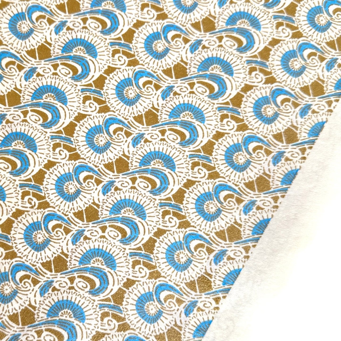 Japanese silkscreen chiyogami paper with a repeat floral pattern in gold an cerulean blue
