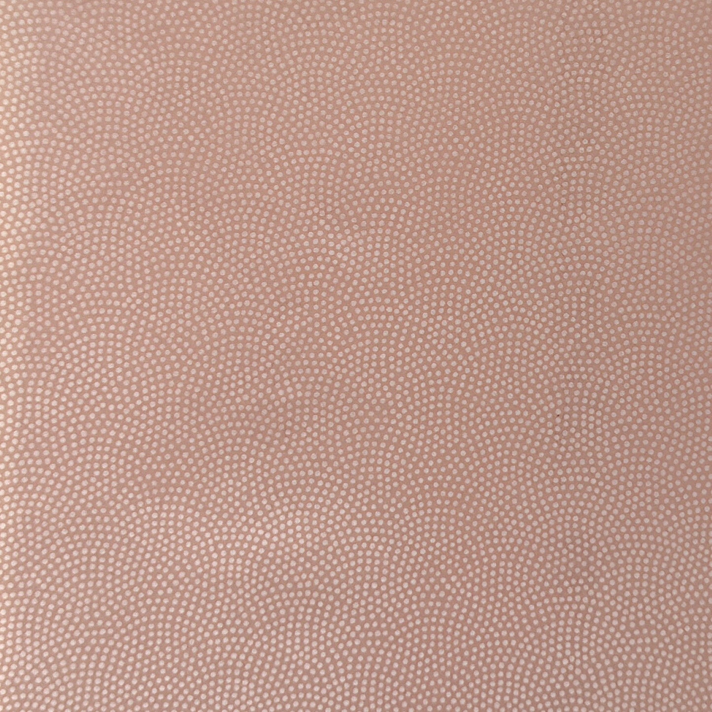 a sheet of Japanese chiyogami paper with a blush pink background and a small pattern of white dots in repeating arch shape