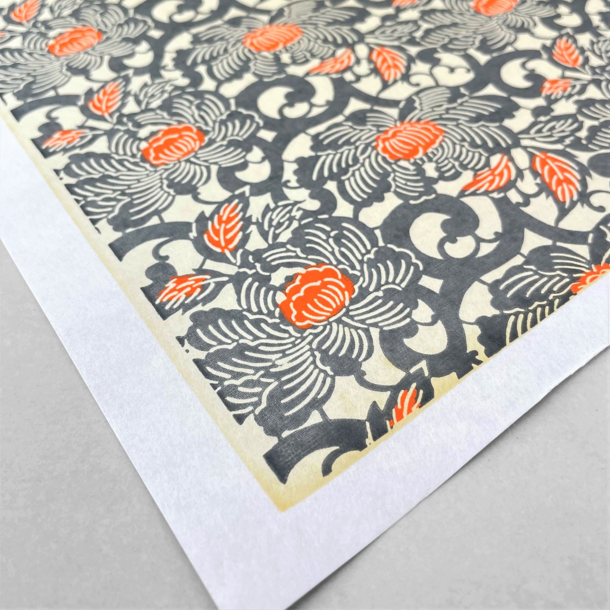 japanese silk-screen handmade paper showing grey and orange peony flower repeat pattern