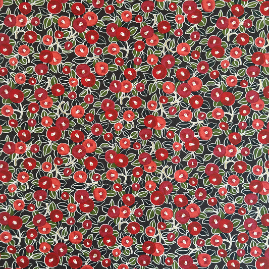 japanese silk-screen handmade paper, chiyogami, with a design showing red and pink camellia flowers and green leaves on black background