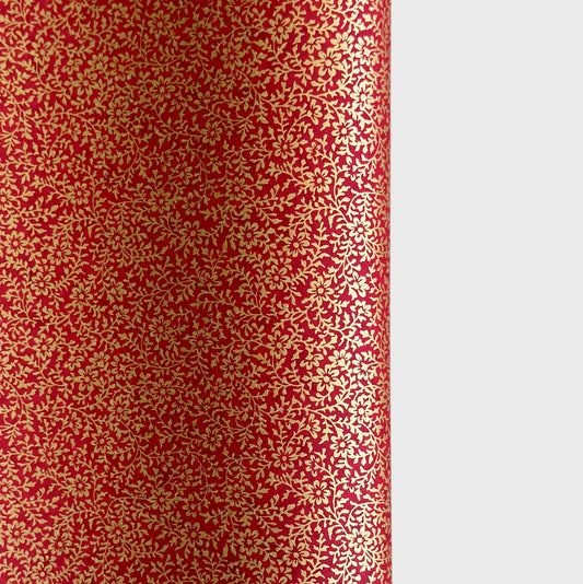 a sheet of Japanese chiyogami yuzen paper with a ditsy gold floral design on a deep red