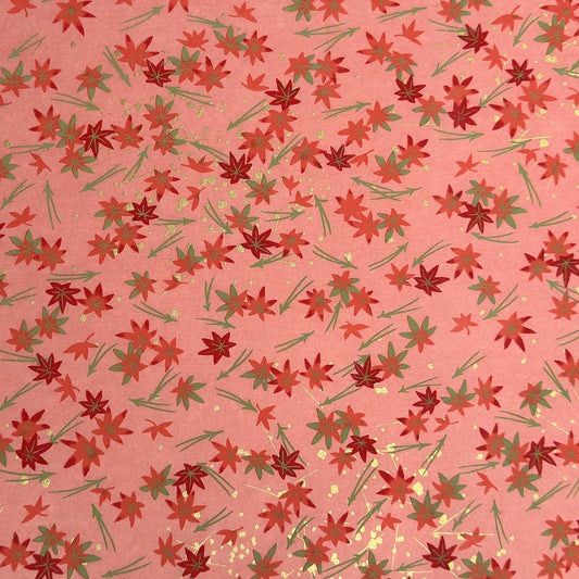 japanese silk-screen handmade paper showing pattern of red falling leaves on coral backdrop and gold highlights