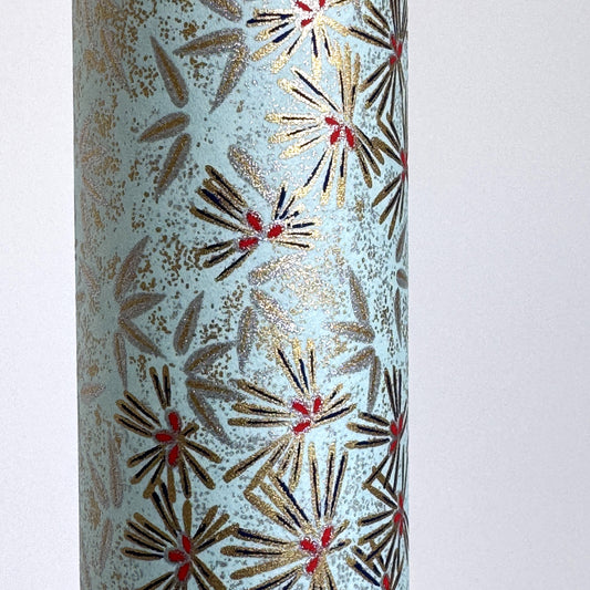 Japanese chiyogami paper silkscreen printed with gold pine needle design on a soft aqua backdrop. Close up