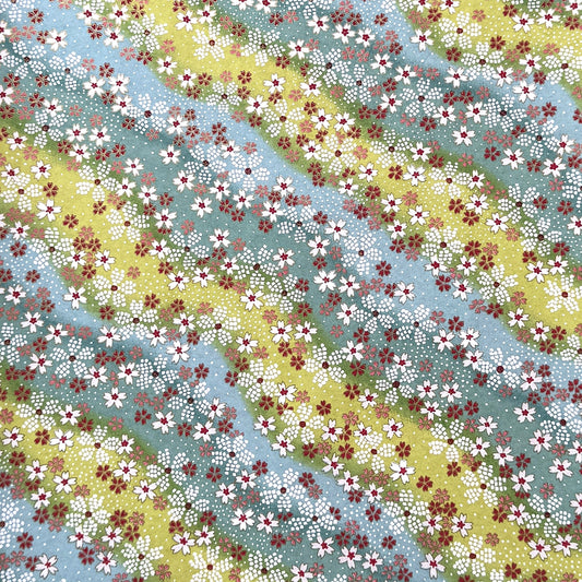 Japanese chiyogami paper silkscreened with a dainty pattern of white sakura flowers on an backdrop of aqua and lime diagonal wavy stripes
