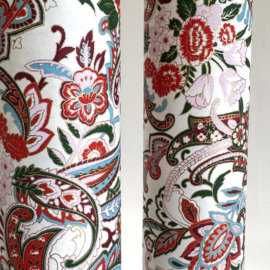 Japanese chiyogami paper silkscreened with a paisley floral style pattern in red, aqua, green and gold on a white background. Rolled & close-up
