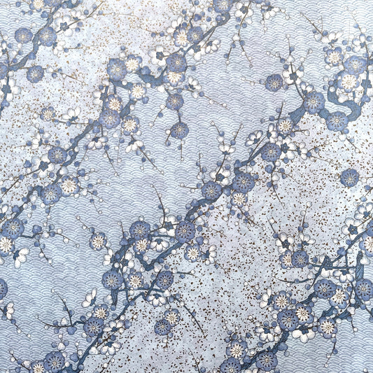 Japanese chiyogami paper with diagonal branches of sky blue plum blossom on a light blue background.