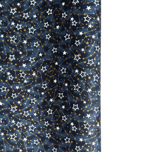 a sheet of Japanese chiyogami yuzen paper with a pattern of white and gold stars on a midnight blue background
