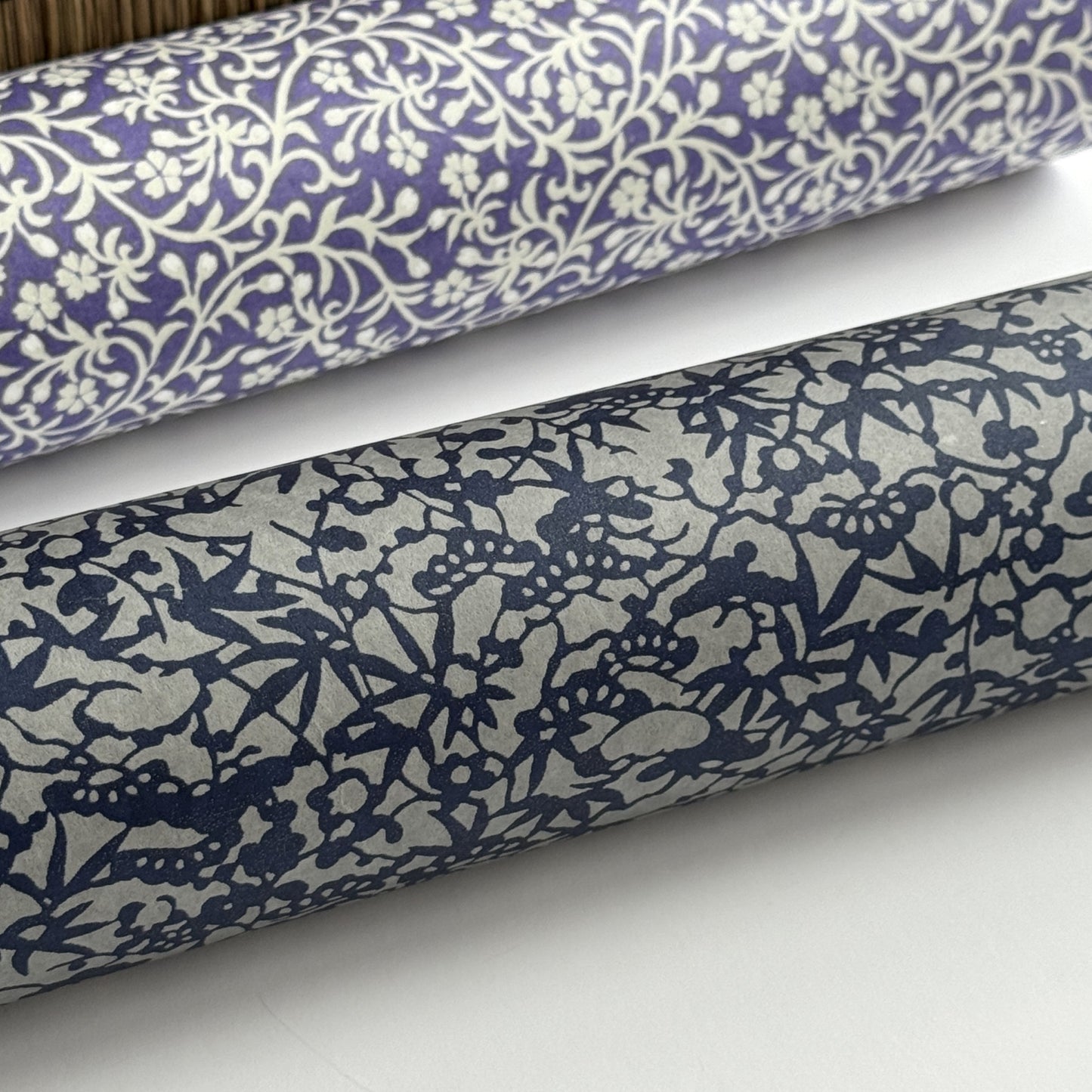 a sheet of Japanese chiyogami yuzen paper with a small abstract pattern in midnight blue on grey. Close up