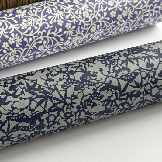 a sheet of Japanese chiyogami yuzen paper with a small abstract pattern in midnight blue on grey. Close up