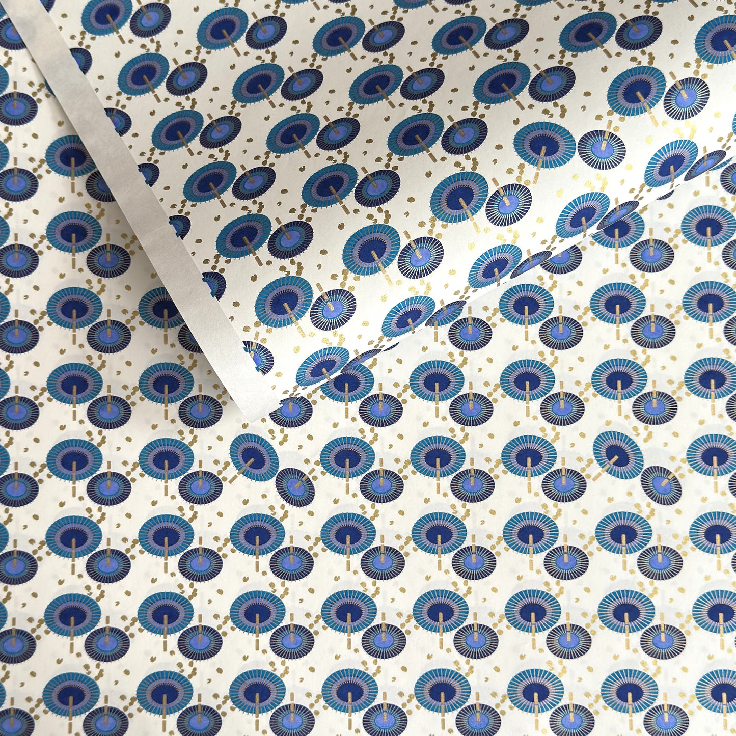 japanese silk-screen handmade paper showing a repeat pattern of blue umbrellas with gold highlights