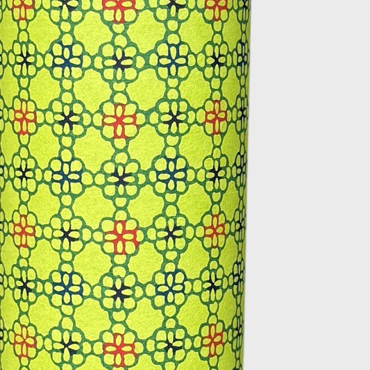 A sheet of Japanese katazome paper with a delicate floral tile repeat pattern on vibrant lime green. Close up