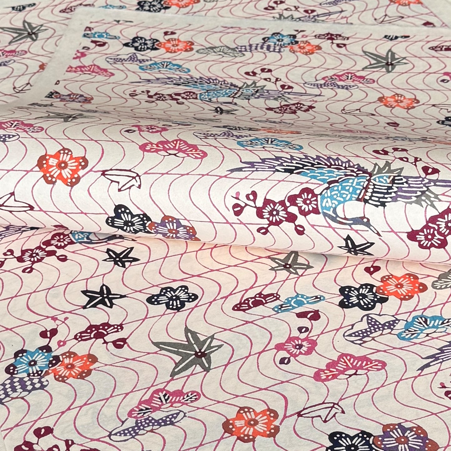 Pattern with cranes and flowers in soft pink, purple, blue and orange. A sheet of katazome paper