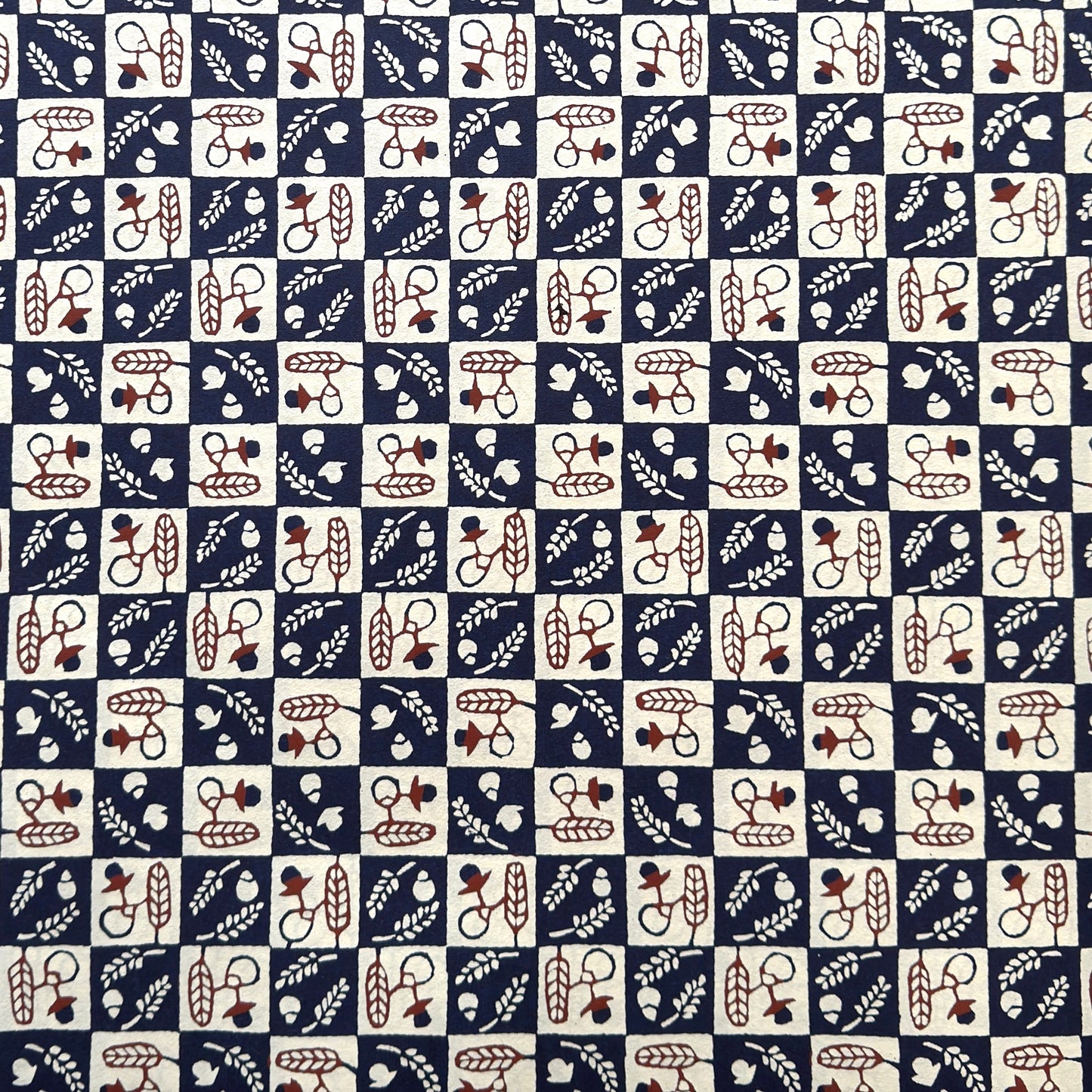 Japanese katazome-shi paper in navy blue and cream chequerboard pattern with motifs of autumn - acorns and wheat.