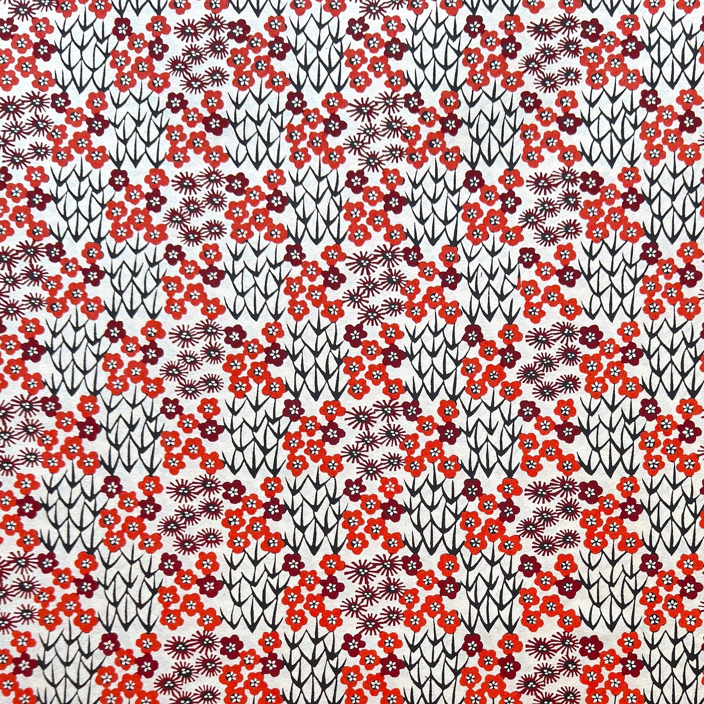 Japanese katazome-shi paper stencil -dyed with a small red flower design, little black stems on ivory paper.