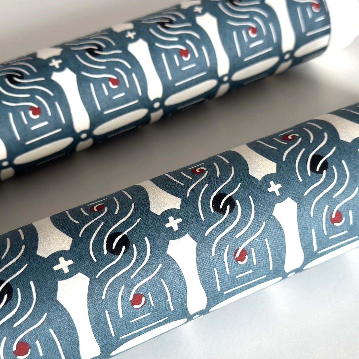 Japanese katazome stencil dyed paper with a repeat pattern of muted blue knots. close up