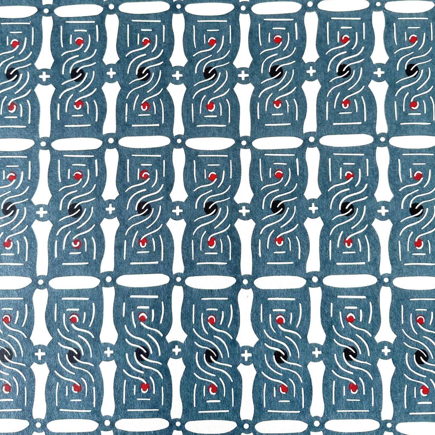 Japanese katazome stencil dyed paper with a repeat pattern of muted blue knots.