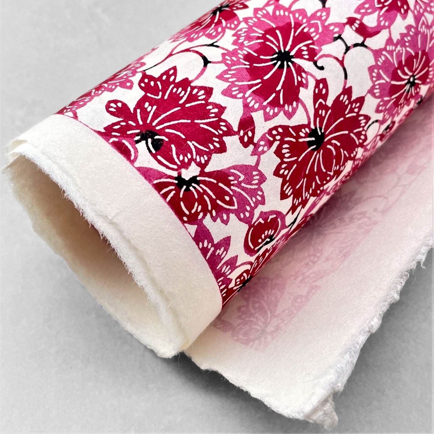 japanese stencil-dyed handmade paper with two-tone pink chrysanthemum repeat pattern
