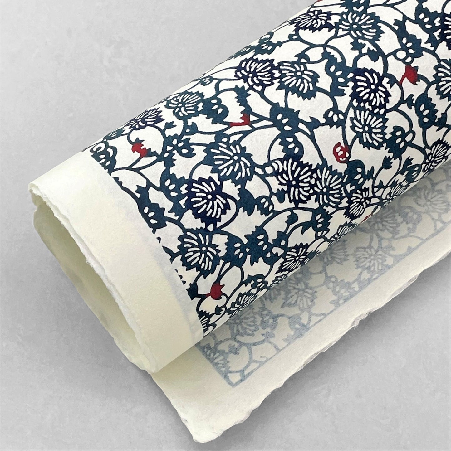 japanese stencil-dyed handmade paper with small scale floral repeat in dark teal and blue