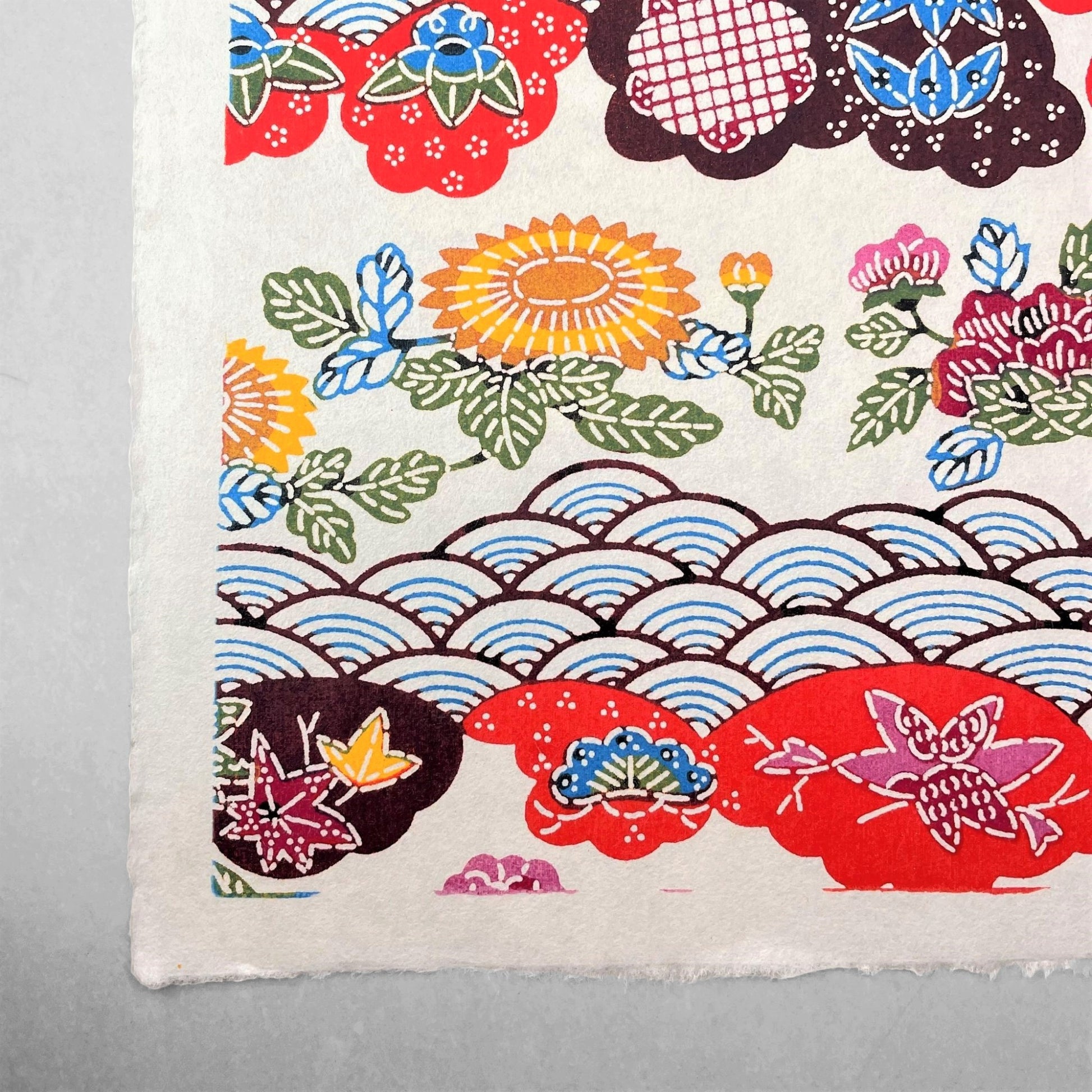 japanese stencil-dyed handmade paper with traditional botanical pattern in red, brown, yellow and blue
