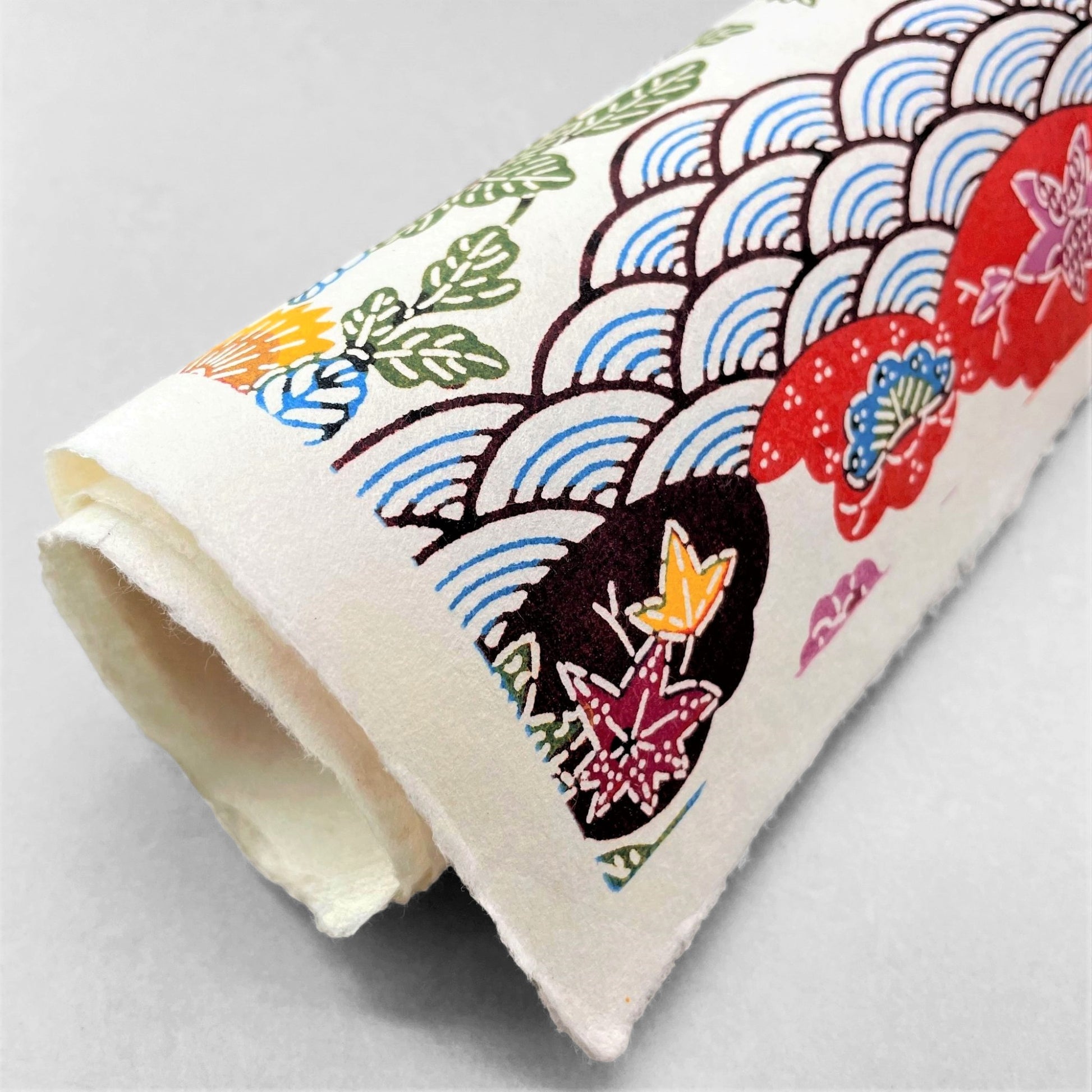 japanese stencil-dyed handmade paper with traditional botanical pattern in red, brown, yellow and blue