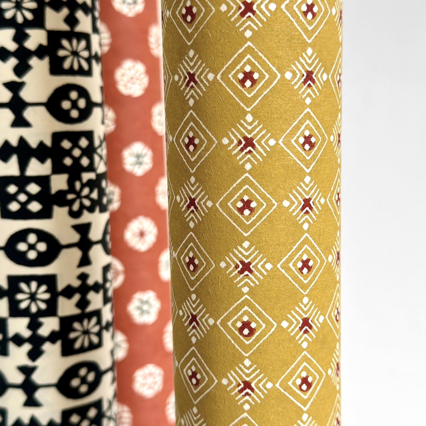 Japanese decorative stencil-dyed paper with repeat diamond pattern in a mustard gold colour. Close-up