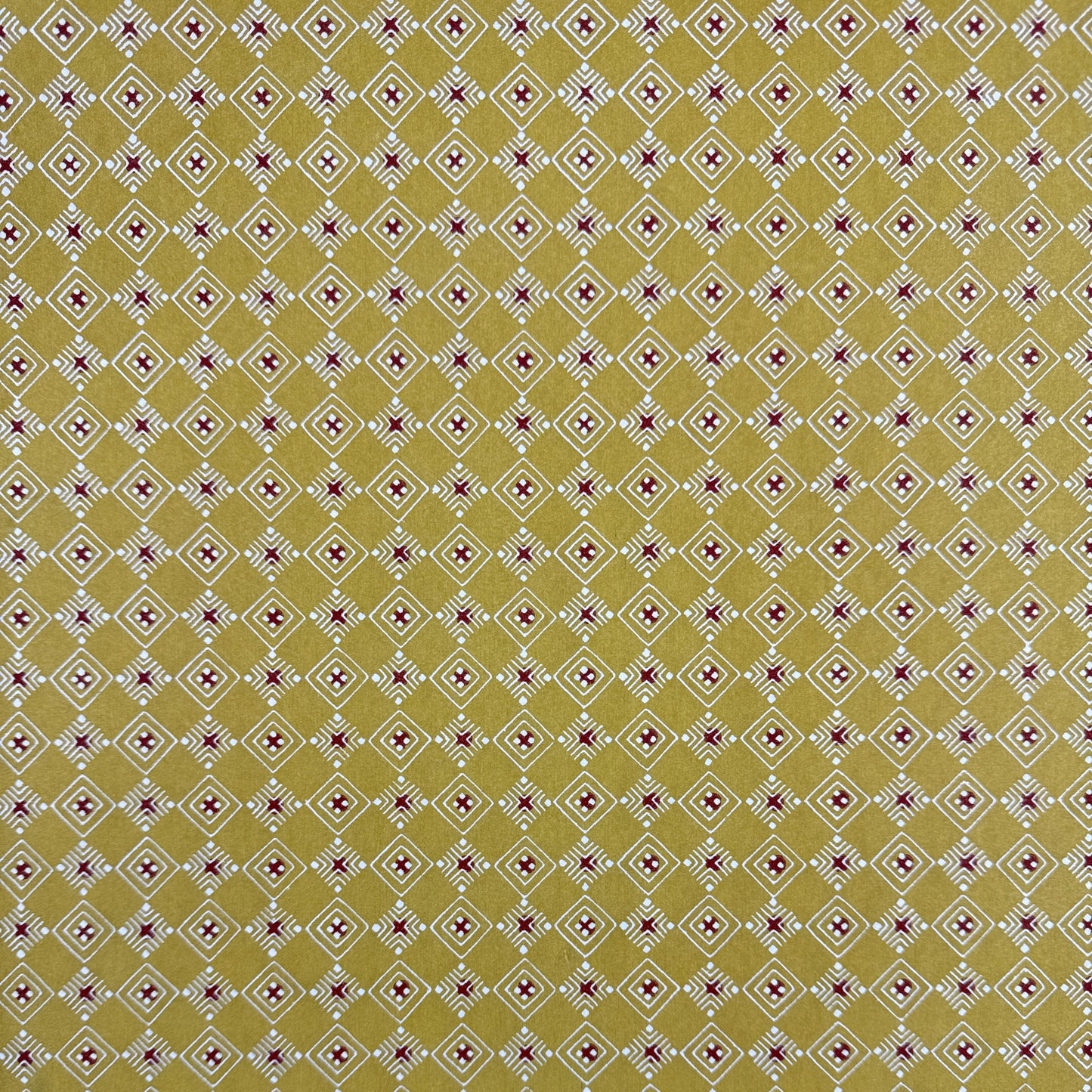 Japanese decorative stencil-dyed paper with repeat diamond pattern in a mustard gold colour.
