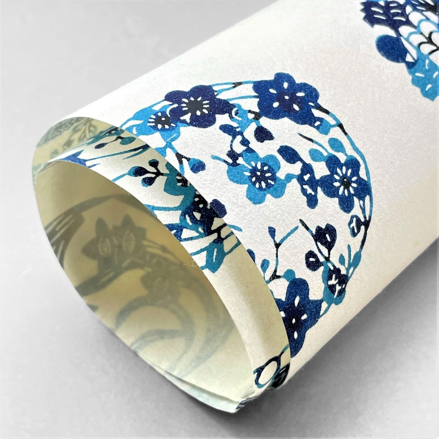 japanese stencil-dyed handmade paper with traditional blue botanical circles pattern on ivory backdrop