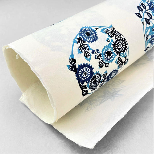 japanese stencil-dyed handmade paper with traditional blue botanical circles pattern on ivory backdrop