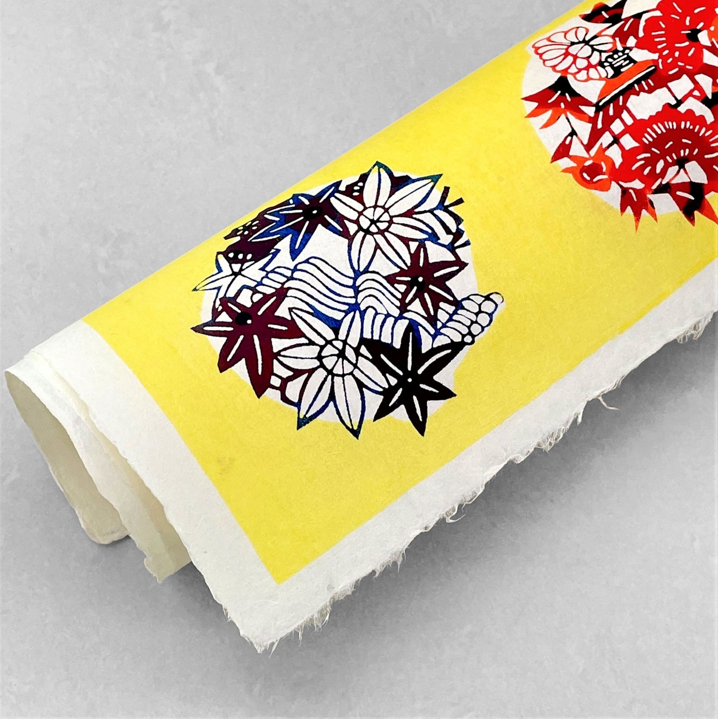 japanese stencil-dyed handmade paper with traditional botanical circles pattern on yellow backdrop