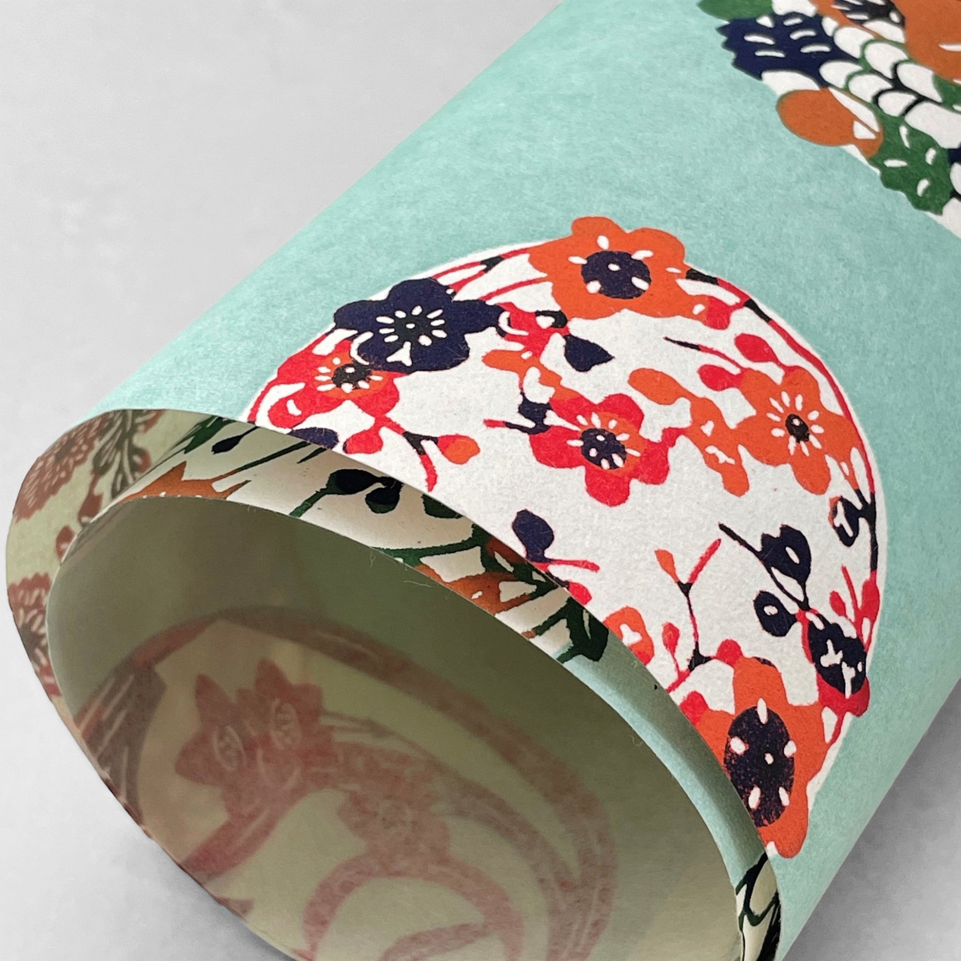 japanese stencil-dyed handmade paper with traditional botanical circles pattern on aqua backdrop