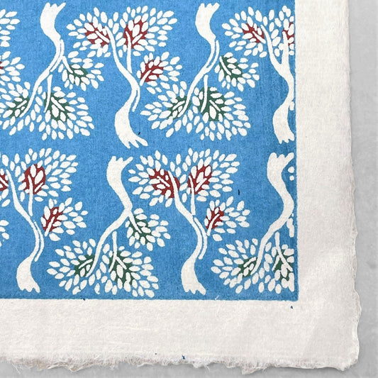 japanese stencil-dyed handmade paper with bonsai tree repeat pattern on blue backdrop