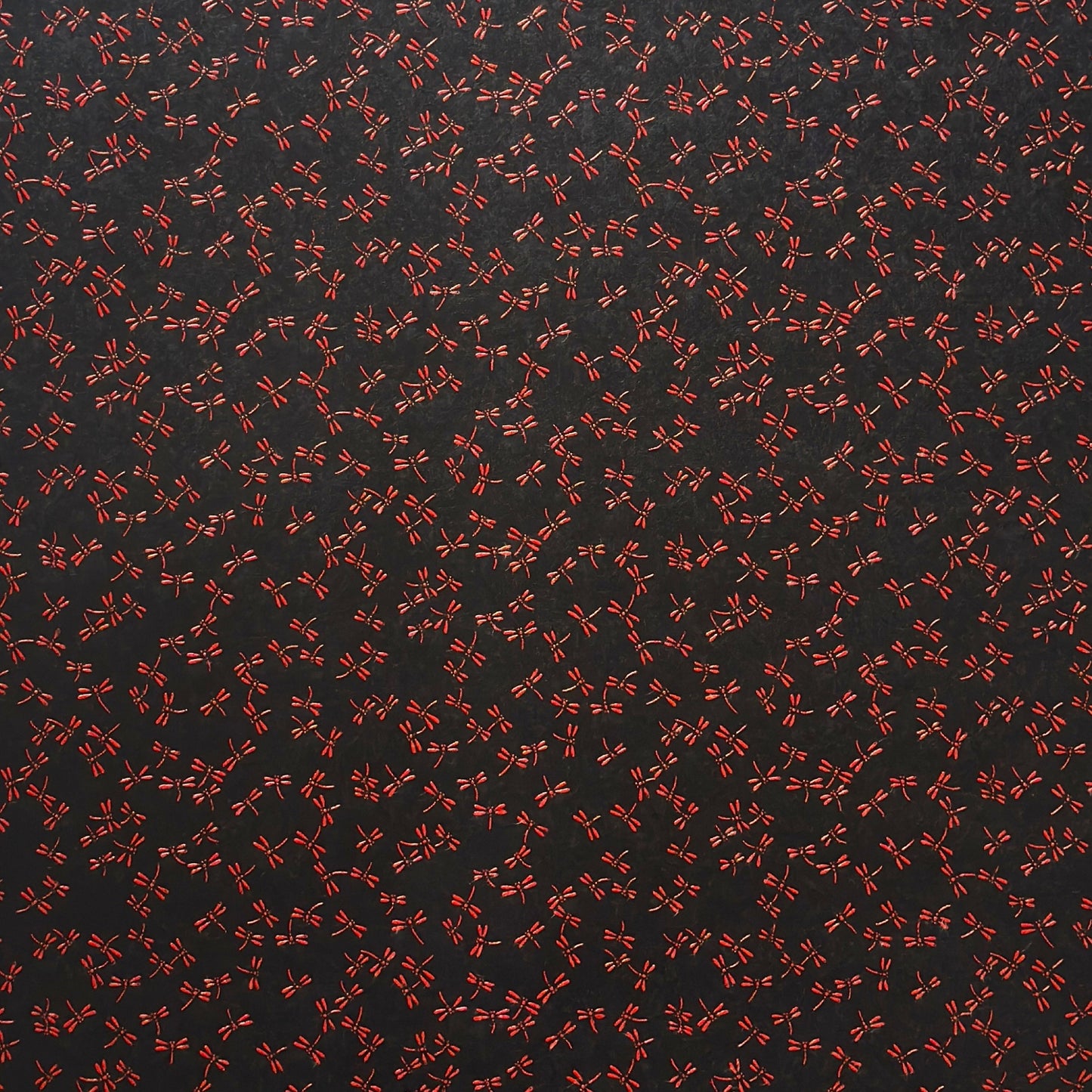 a sheet of Japanese lacquered yuzen paper with black background and little red dragonflies