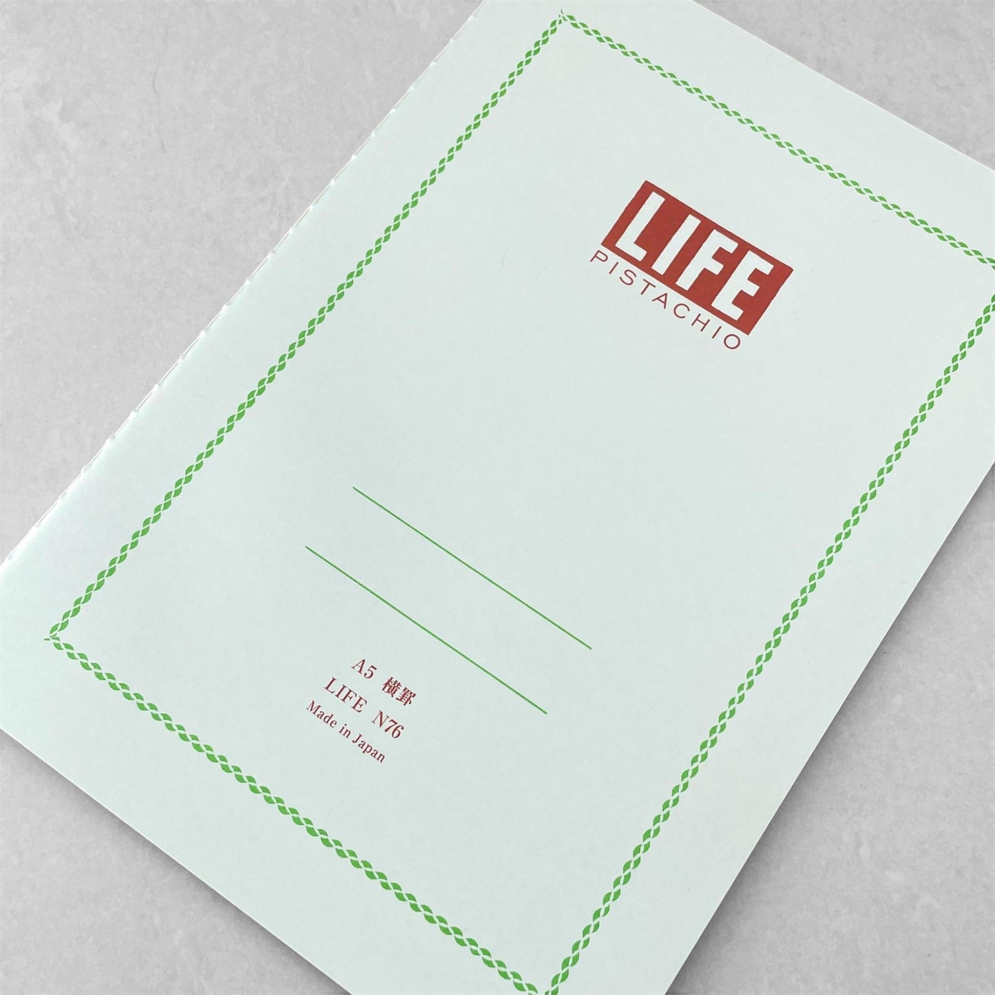 A5 softcover notebook with a soft green cover with green border and branding by Japanese brand Life Japan