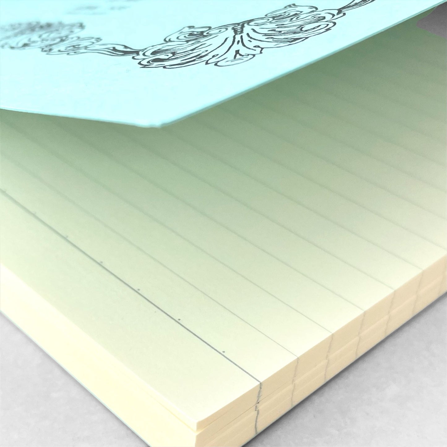 Softcover notebook with lined pages. The cover is plain aqua with a decorative black border and branding, Life Noble Ruled by Japanese brand Life