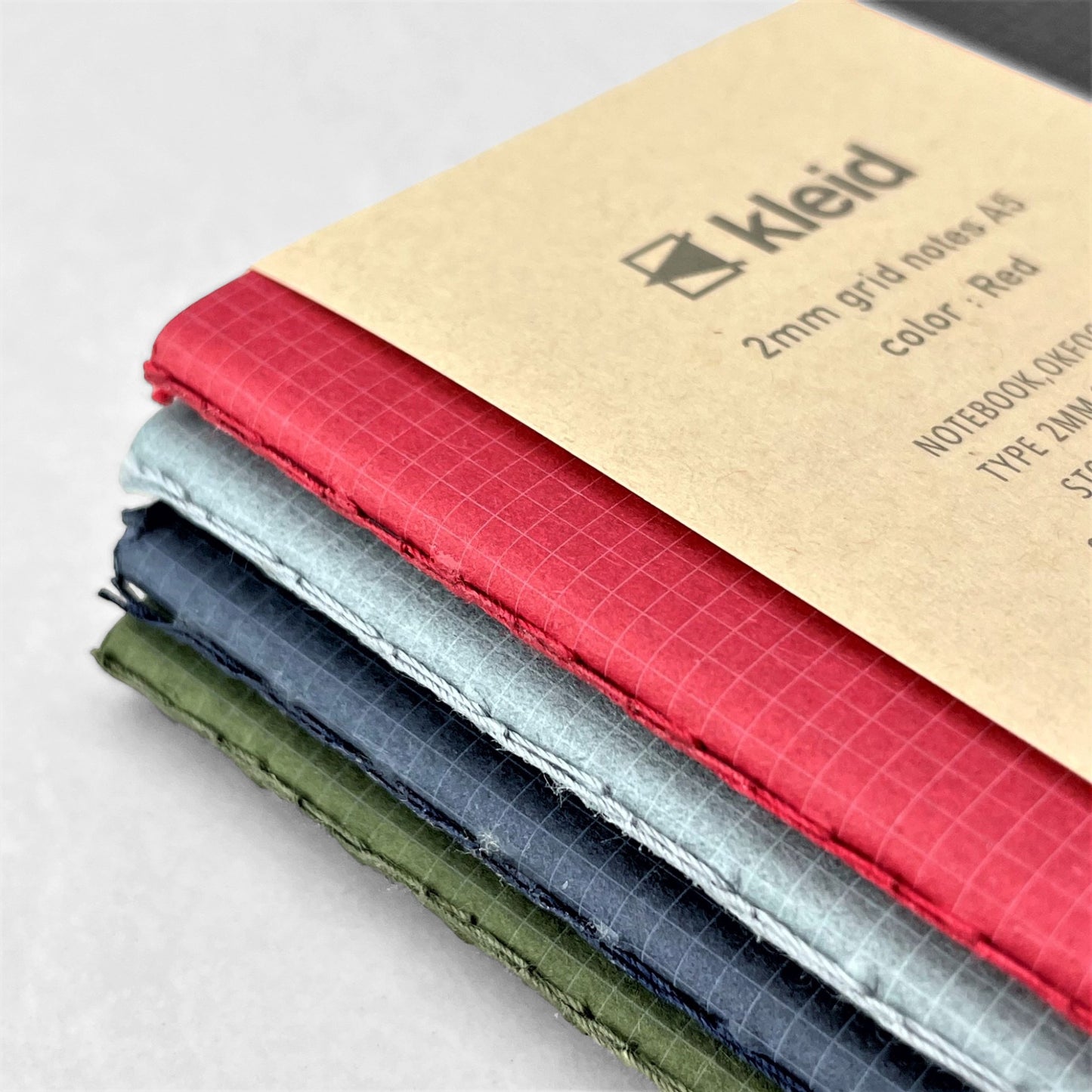 A5 soft cover notebook, cover is red with a small white grid pattern by Japanese brand Kleid