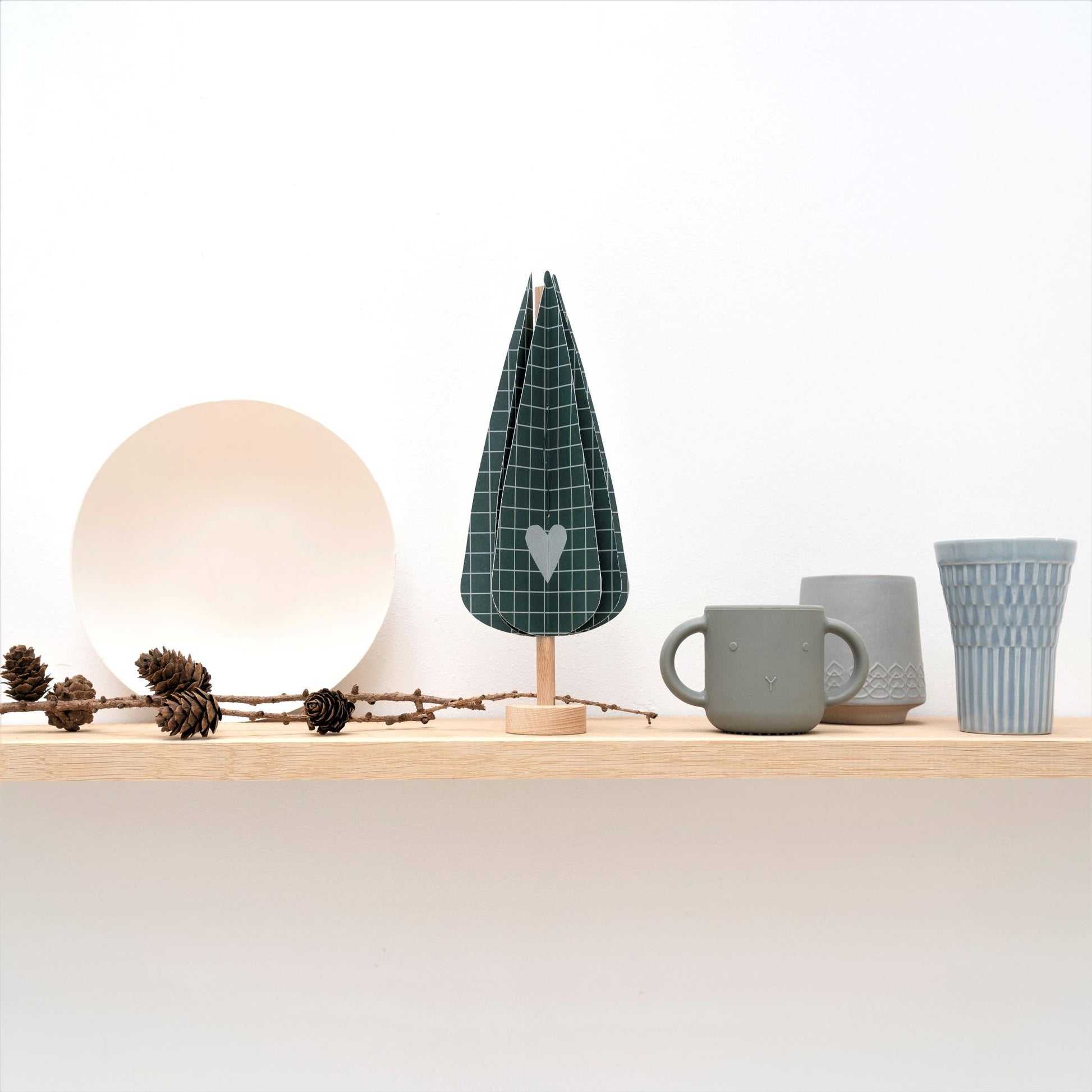 paper craft kit of a dark green cypress tree by Jurianne Matter, pictured on a shelf