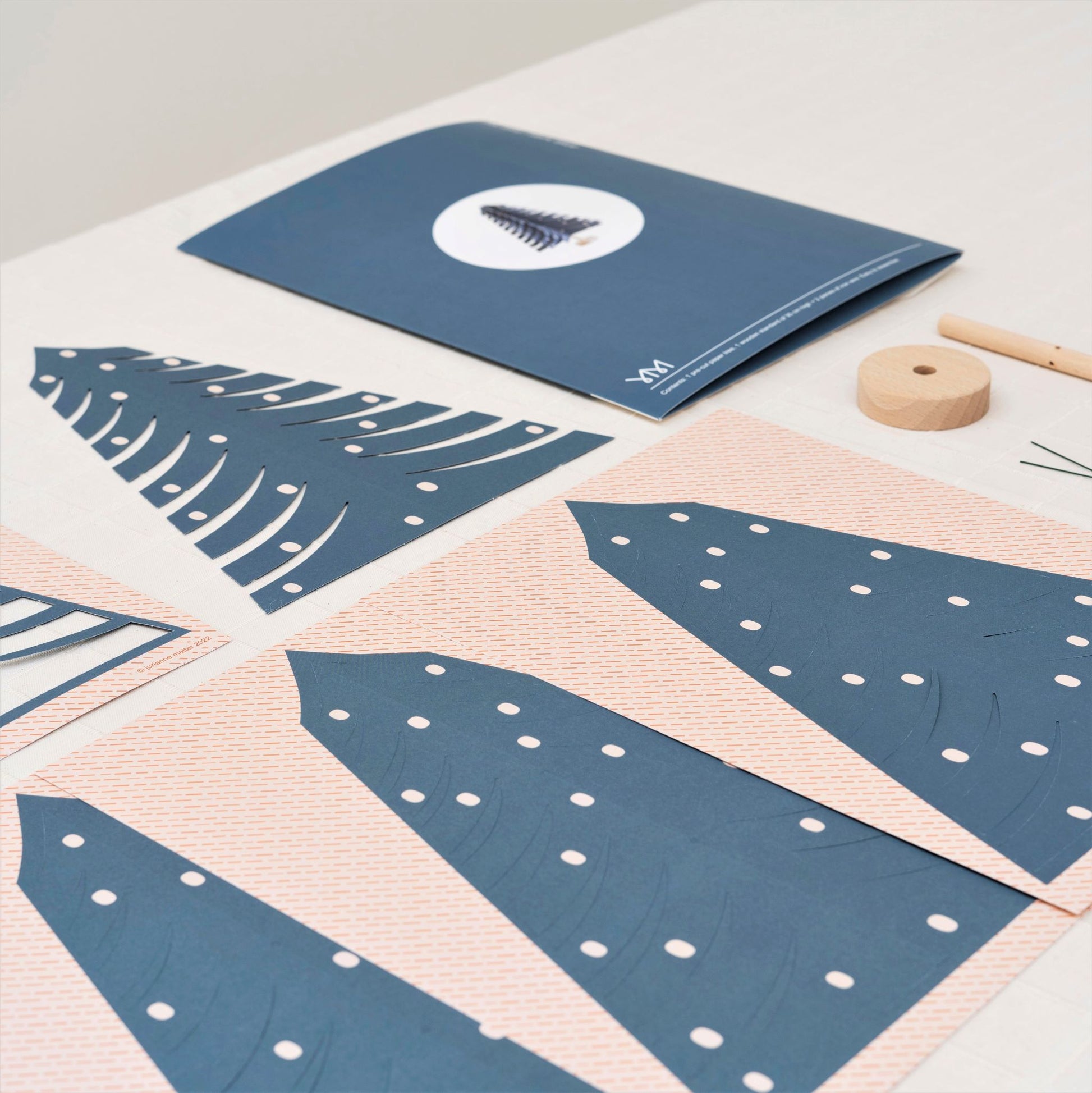 A blue paper fir tree decoration by Jurianne Matter, pictured ready to assemble