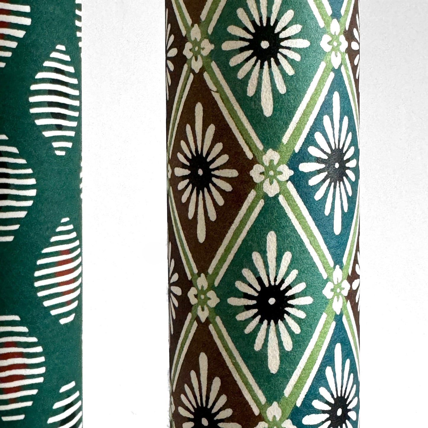 A Japanese stencil-dyed patterned paper with a repeat pattern of floral diamonds in tones of blue, aqua, brown and white. Close-up