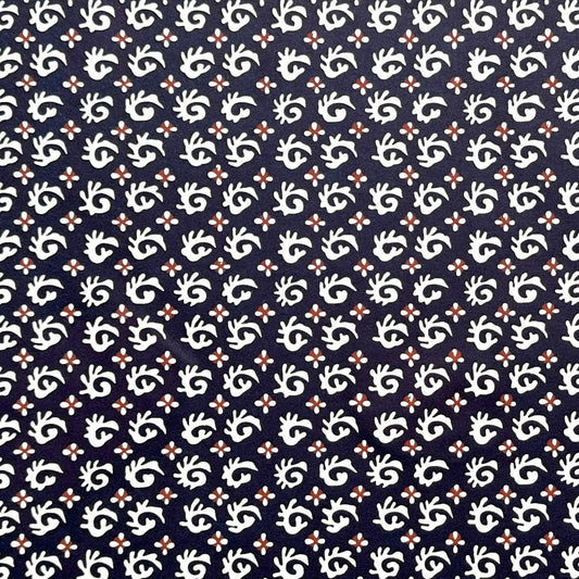 japanese stencil-dyed paper with a white swirl geometric repeat pattern on a dark inky blue background
