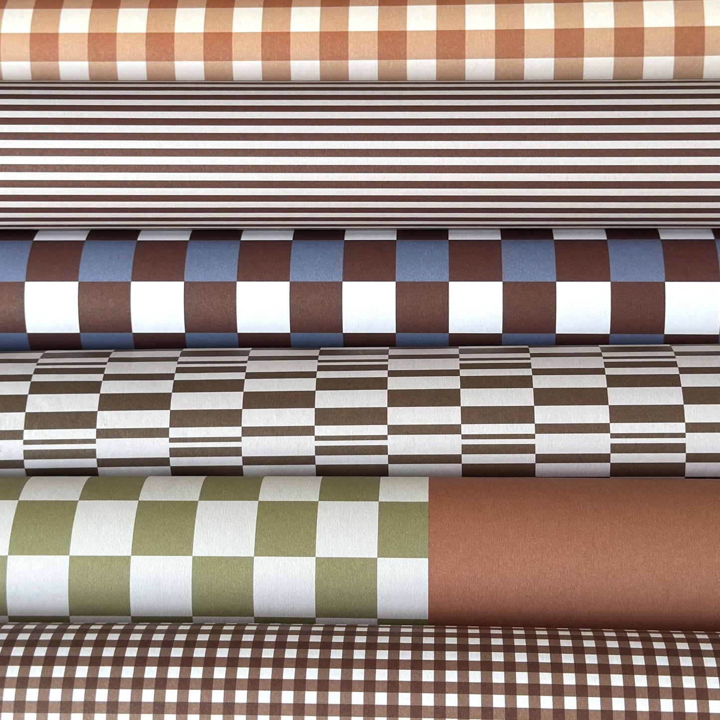 a sheet of checkered wrapping paper in brown, blue and white. Pictured with other designs
