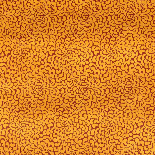 a sheet of screen printed Nepalese lokta paper with a repeat floral design in dark orange on an amber yellow lokta paper