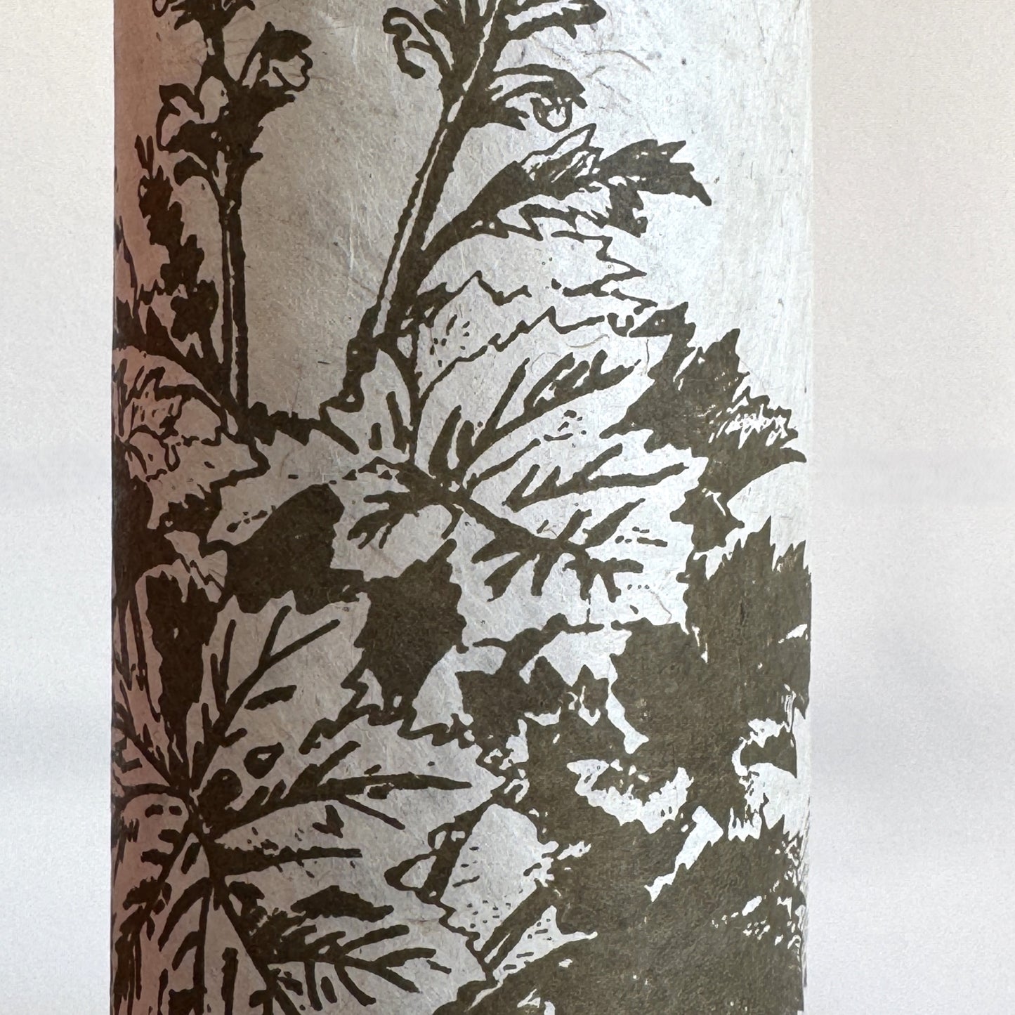 Nepalese handmade decorative lokta paper sheet with a Toile de Jouy style pattern of an agapanthus flower is dark moss screen printed on an ivory lokta paper. close up