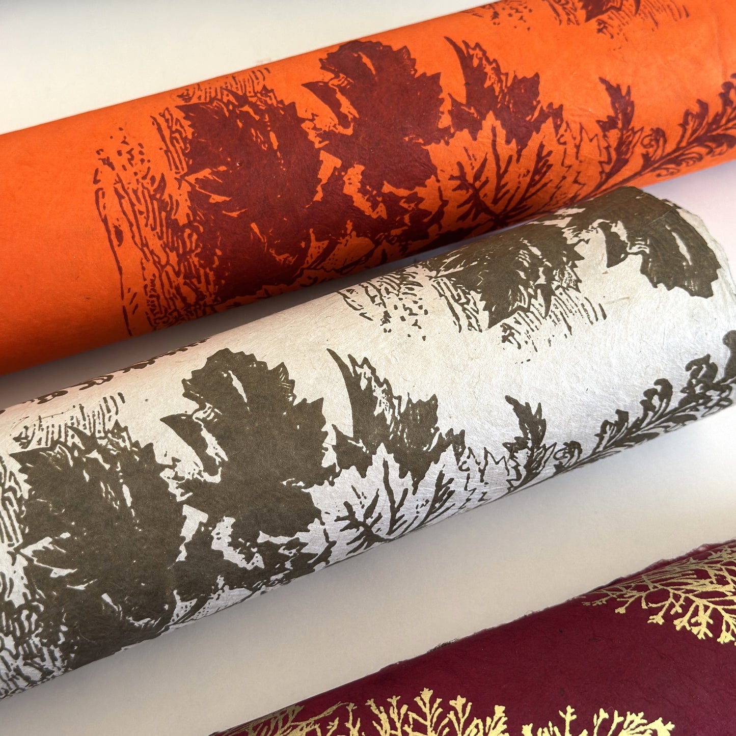 Nepalese handmade decorative lokta paper sheet with a Toile de Jouy style pattern of an agapanthus flower is dark moss screen printed on an ivory lokta paper. Rolled