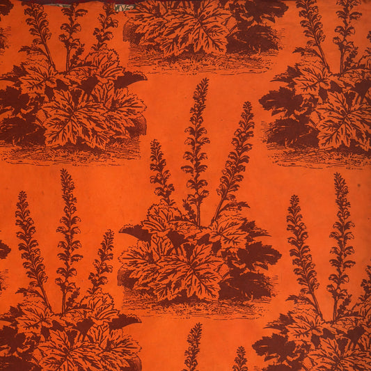 Nepalese handmade decorative lokta paper sheet with a Toile de Jouy style pattern of an agapanthus flower in burgundy screen printed on an orange lokta paper