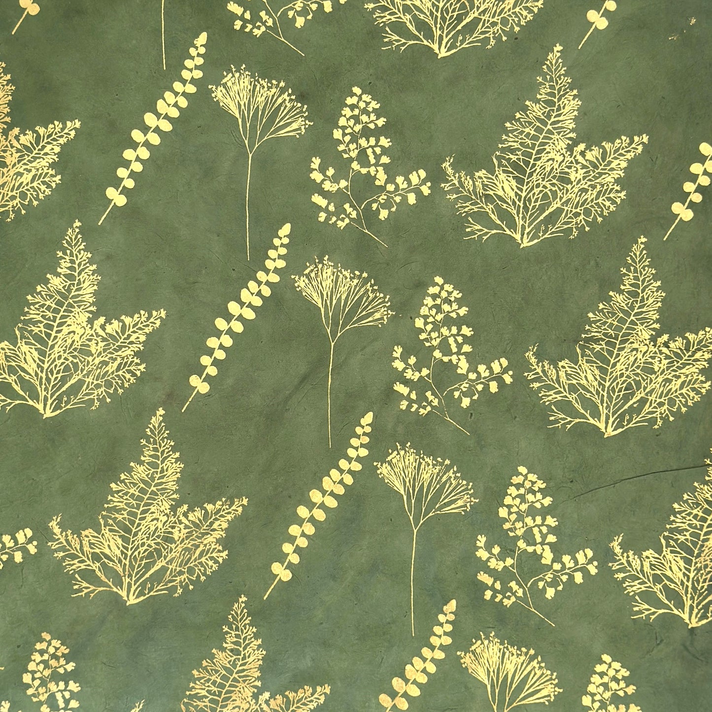 Nepalese handmade decorative lokta paper sheet with gold leaves screen printed on a green lokta paper