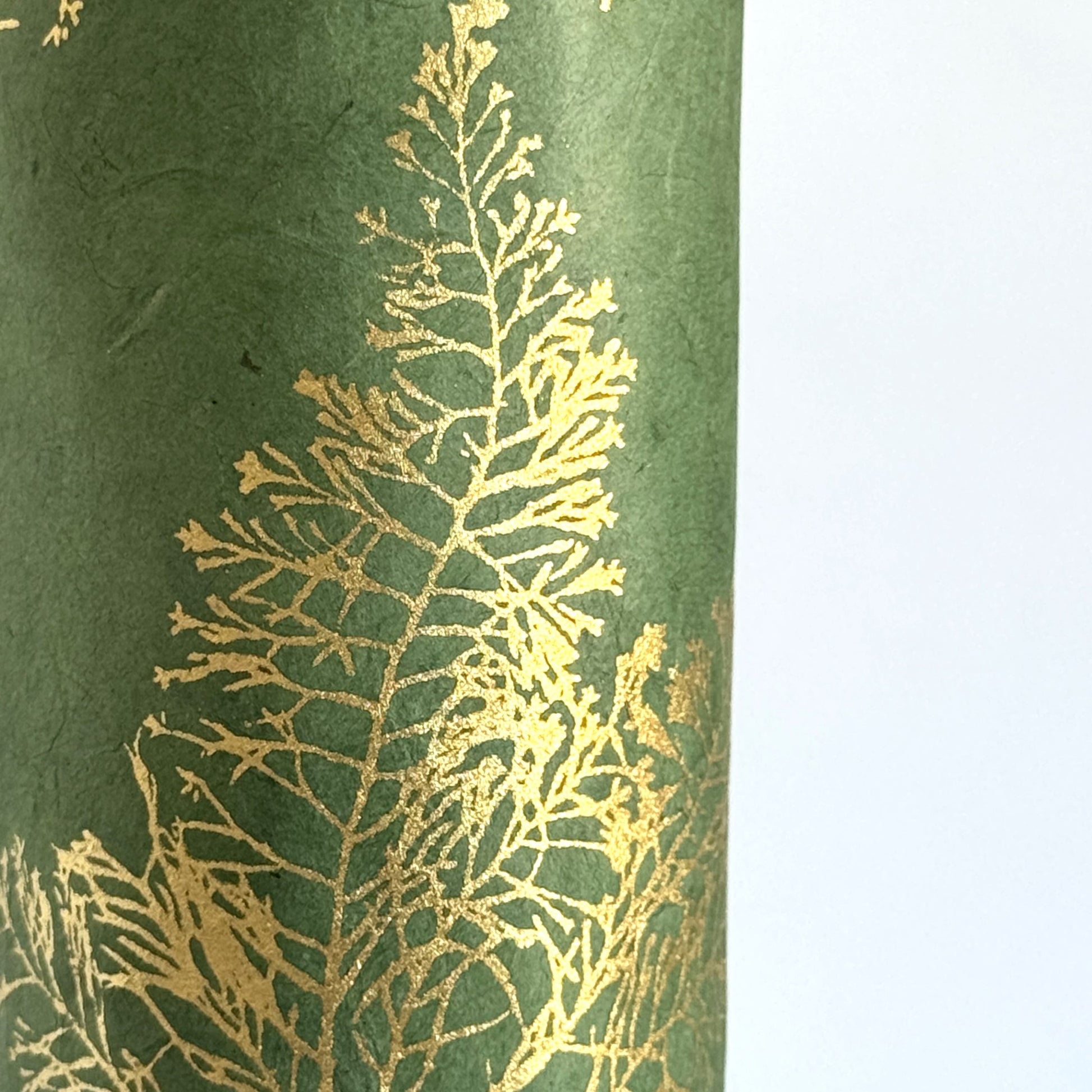 Nepalese handmade decorative lokta paper sheet with gold leaves screen printed on a green lokta paper. Close up