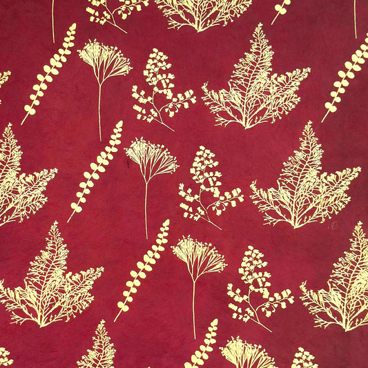 Nepalese handmade decorative lokta paper sheet with gold leaves screen printed on a burgundy red lokta paper
